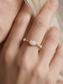 Close-up of the oval opal, round side stones and botanical gold setting