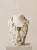 Avēro Sylvan Court beaded tassel statement necklace displayed on a distressed classical stone bust